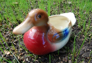 A Ceramic Mallard Duckling Sitting on Grass